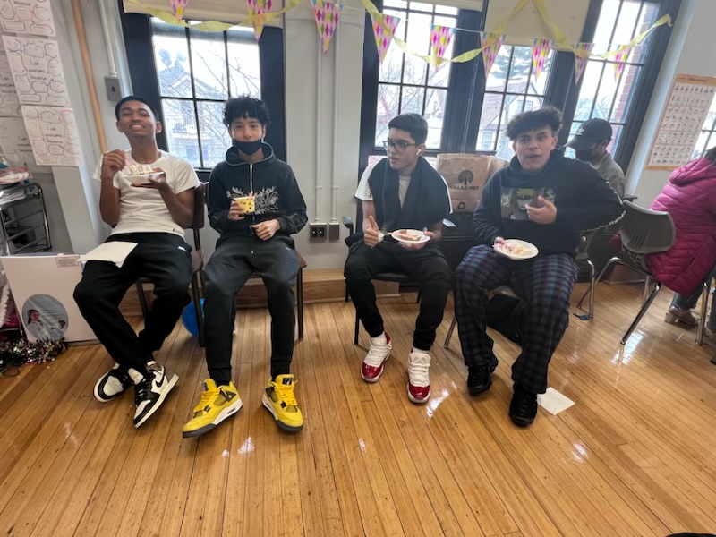 4 students seated in a classroom enjoying ice cream 