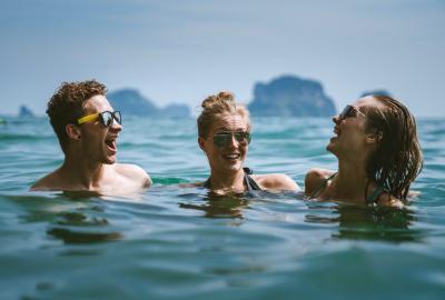 3 vacationers swimming at a beach resort 